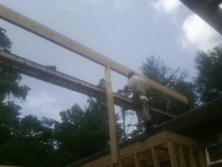 Carpenter setting a ridge beam over a new addition frame — Ice Dam Removal by Roofing Brothers in Gainesboro