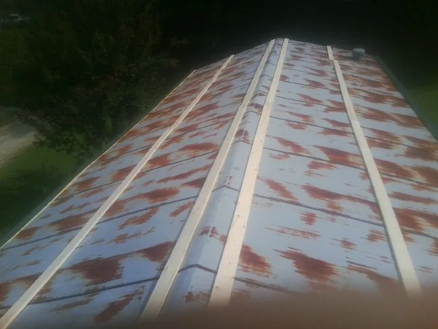 Rusted metal roof panels with new wood purlins before replacement — Storm Damage Roof Repair in Gainesboro by Roofing Brothers