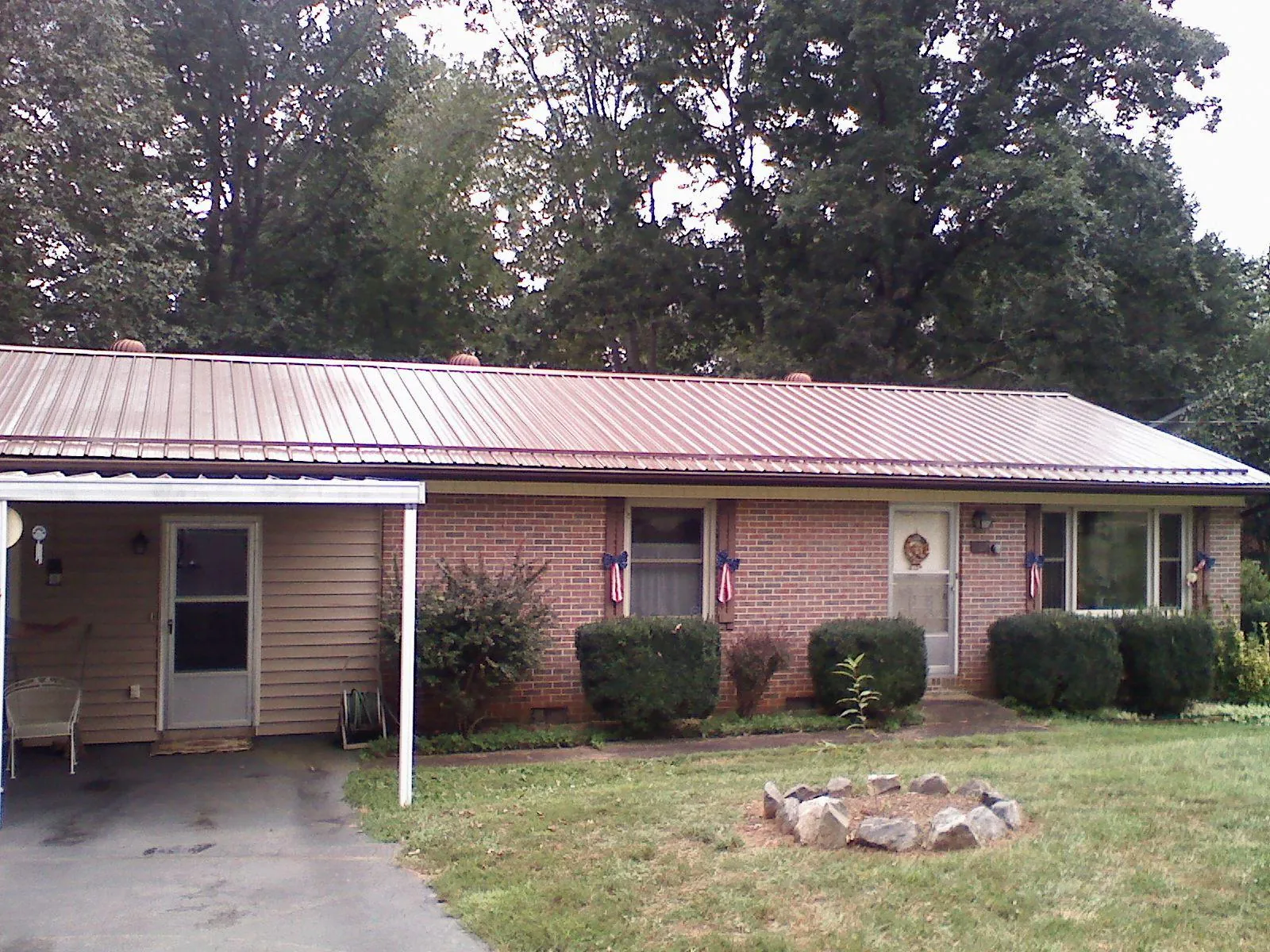 Bronze metal roof and carport on a brick ranch home — Roof Repair work by our crew in Gainesboro